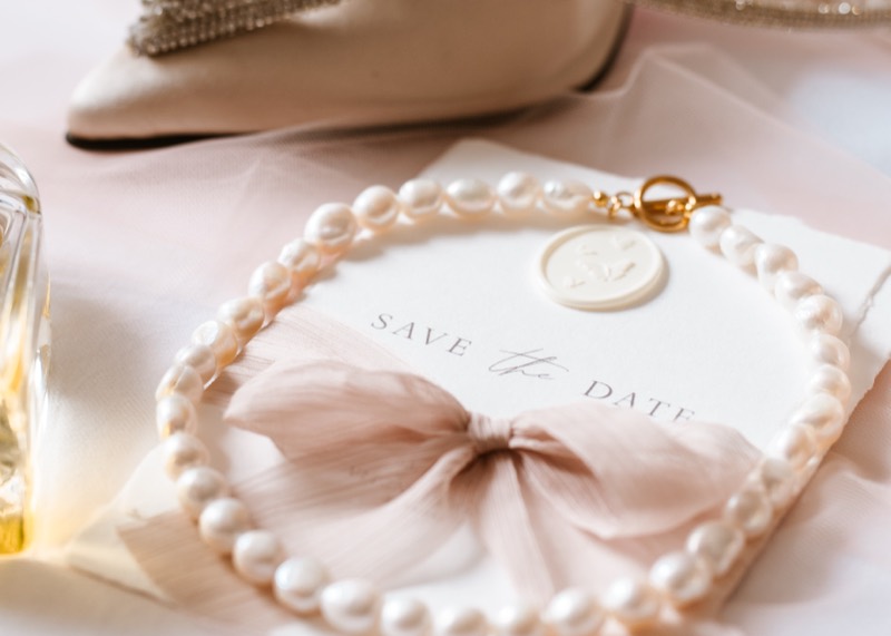 Save-the-Date-Karte mit Perlensaum und Schleife