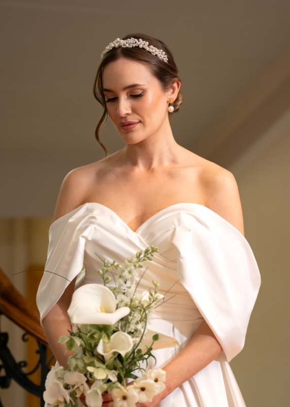 Braut mit Diadem und weissem Strauss im Innenraum
