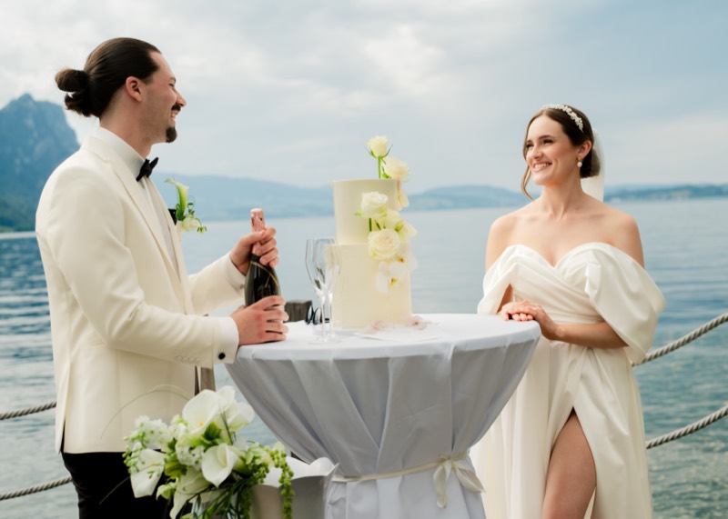 Brautpaar am Stehtisch mit Hochzeitstorte vor dem See